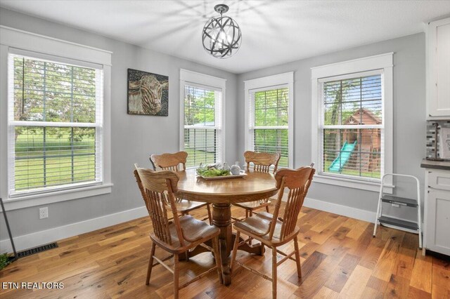dining space with light wood-style floors, baseboards, and a wealth of natural light