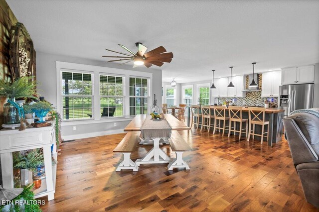 dining space featuring baseboards, ceiling fan, wood finished floors, and visible vents