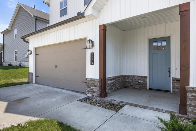 doorway to property featuring concrete driveway and stone siding