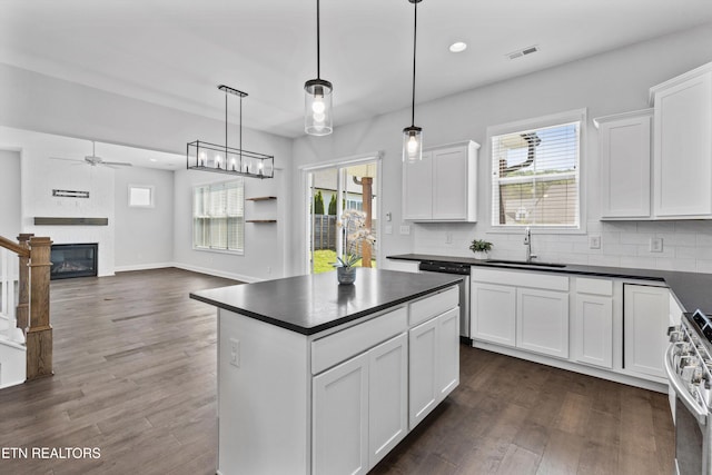 kitchen featuring a sink, a ceiling fan, dark countertops, and stainless steel appliances