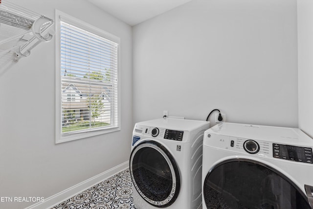 laundry room featuring baseboards, laundry area, washing machine and dryer, and tile patterned floors