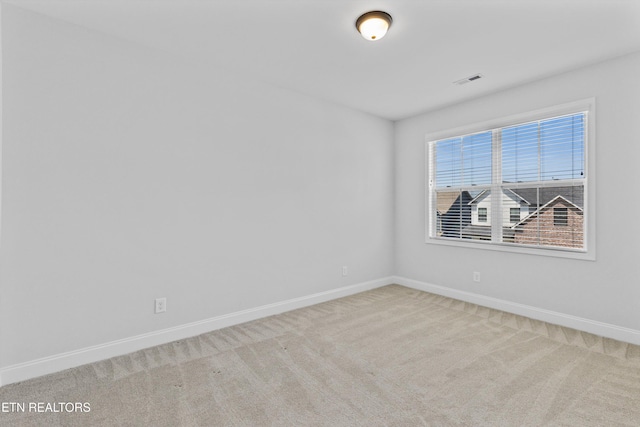 carpeted spare room with baseboards and visible vents