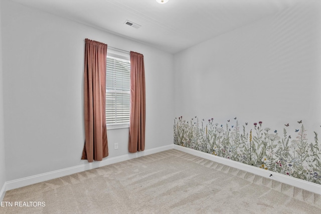 carpeted spare room featuring baseboards and visible vents