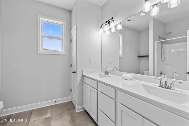 bathroom with toilet, baseboards, a sink, and a shower