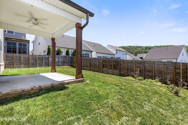 view of yard with a patio, a ceiling fan, a fenced backyard, and a residential view