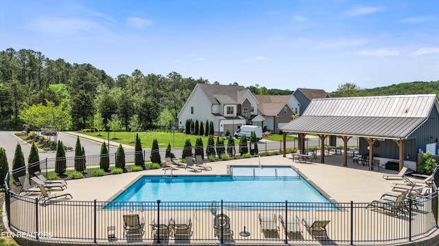 community pool with fence and a patio area