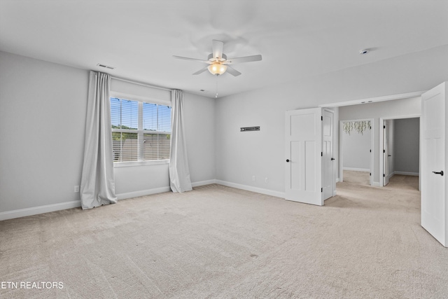 interior space featuring carpet floors, a ceiling fan, baseboards, and visible vents
