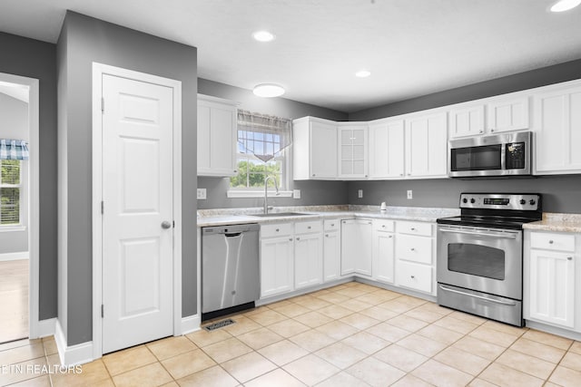 kitchen featuring visible vents, a sink, stainless steel appliances, recessed lighting, and white cabinetry