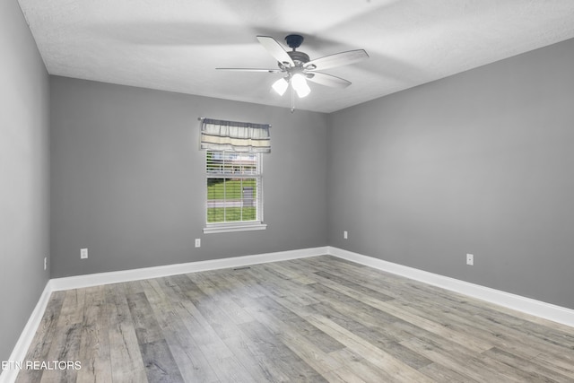 unfurnished room featuring baseboards, ceiling fan, and wood finished floors