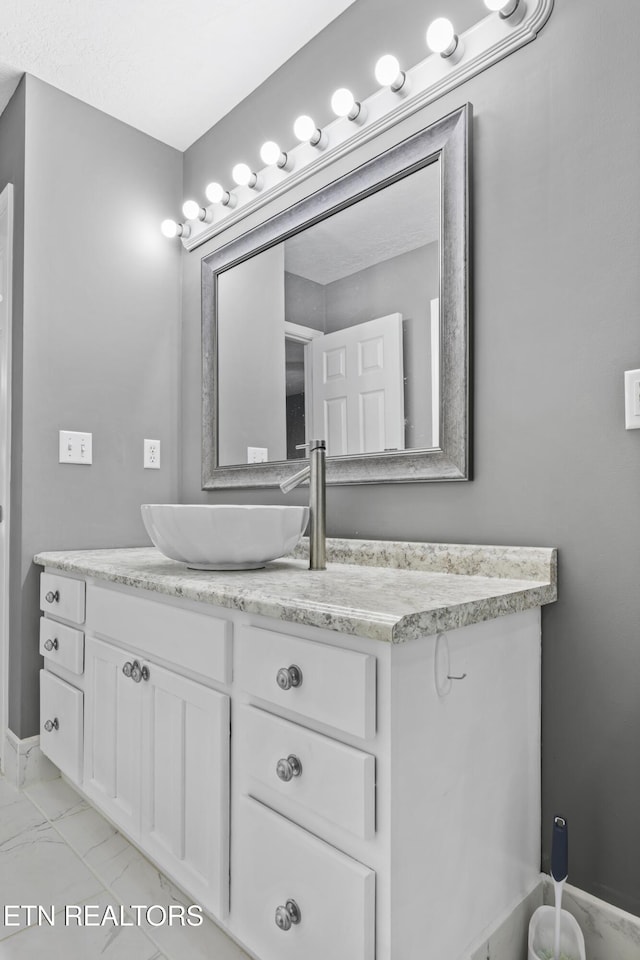 bathroom featuring vanity and marble finish floor