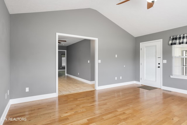 interior space featuring ceiling fan, visible vents, vaulted ceiling, baseboards, and light wood-style floors