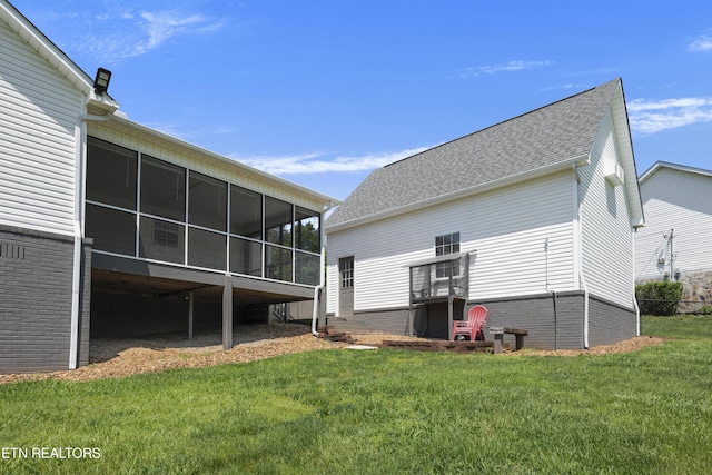 back of property featuring a yard and a sunroom
