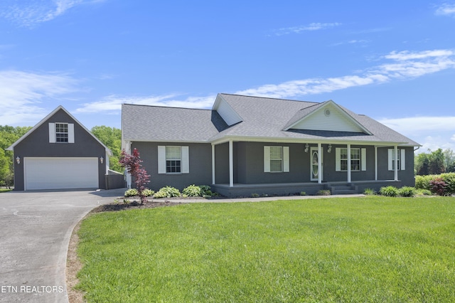 view of front facade with a front lawn, roof with shingles, concrete driveway, a porch, and a detached garage
