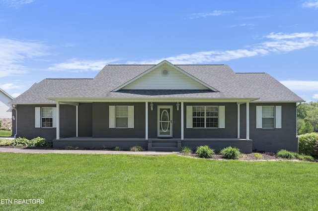 view of front of property featuring brick siding, a front lawn, and roof with shingles