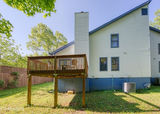 back of house featuring a lawn, a chimney, a wooden deck, and crawl space