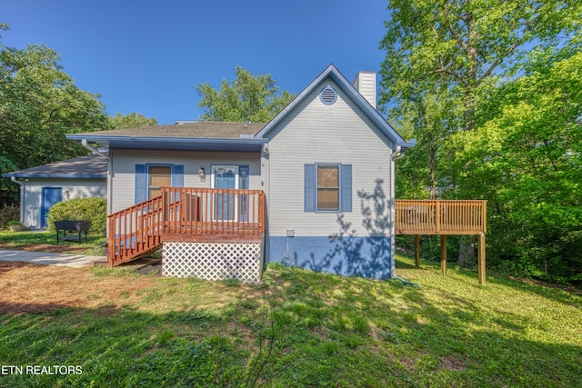 back of house with a yard, a chimney, and a wooden deck