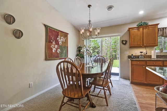 dining space featuring baseboards, a chandelier, a wealth of natural light, and visible vents
