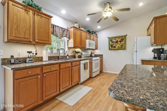 kitchen featuring ceiling fan, a sink, white appliances, brown cabinetry, and light wood-style flooring