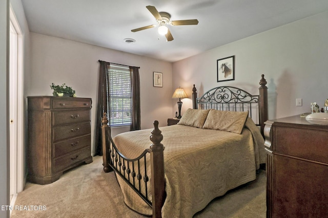 bedroom featuring ceiling fan, visible vents, and light carpet