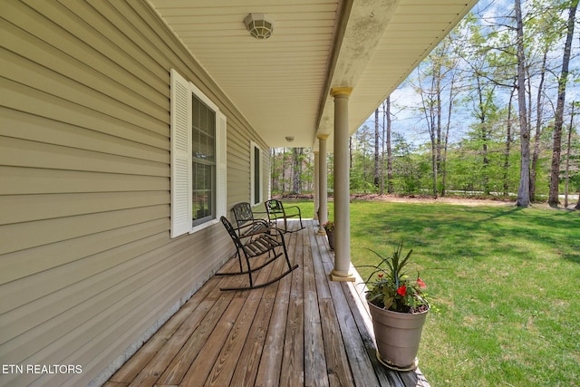 deck featuring covered porch and a yard