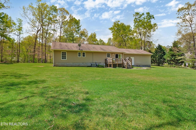 rear view of house with central AC, a yard, and a deck