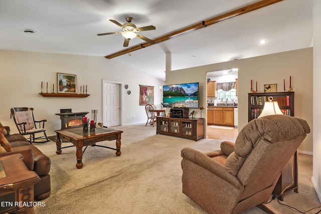 living room featuring baseboards, ceiling fan, lofted ceiling with beams, and light carpet