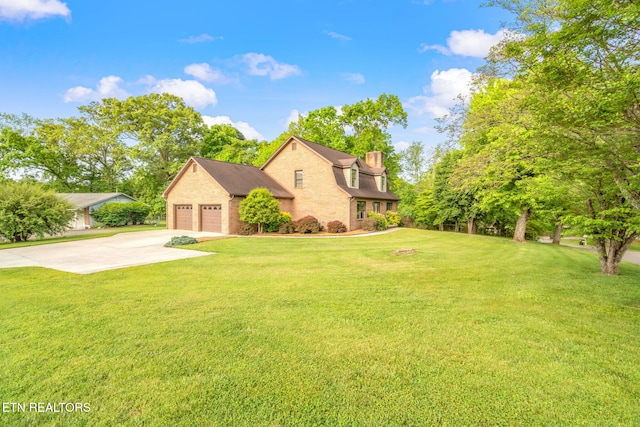 traditional-style house featuring a garage, a chimney, driveway, and a front lawn