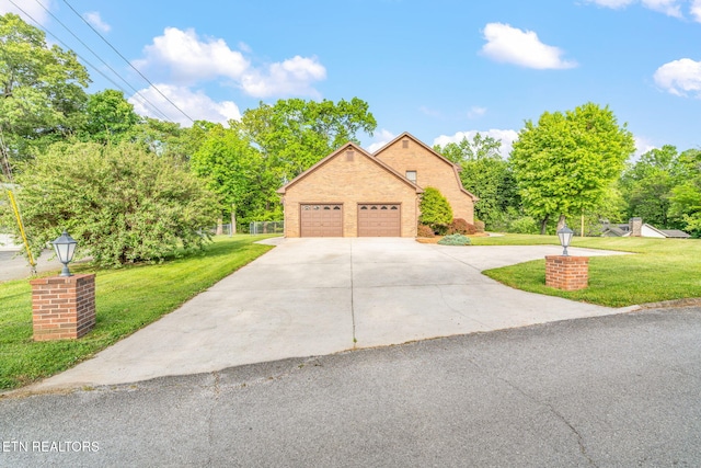 view of front of property with concrete driveway, brick siding, a front yard, and a garage