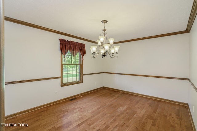 unfurnished room featuring crown molding, baseboards, an inviting chandelier, and light wood finished floors