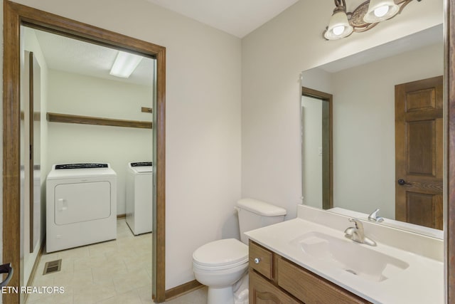 bathroom with visible vents, vanity, tile patterned floors, toilet, and washer and clothes dryer