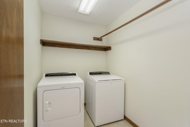 washroom featuring light tile patterned floors, laundry area, and washer and clothes dryer