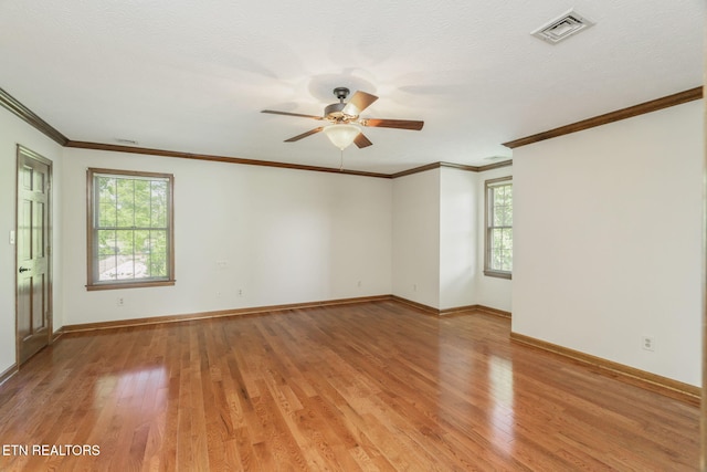 unfurnished room featuring baseboards, a ceiling fan, light wood finished floors, and visible vents