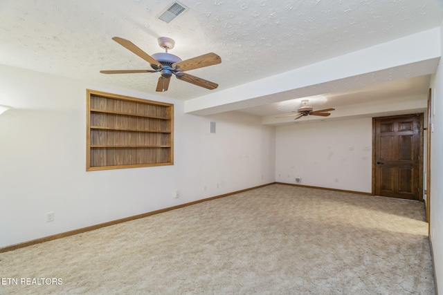 carpeted spare room featuring baseboards, a ceiling fan, a textured ceiling, and visible vents
