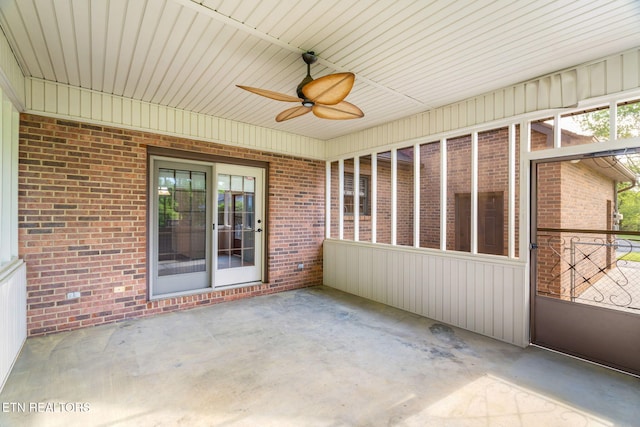 unfurnished sunroom featuring a ceiling fan