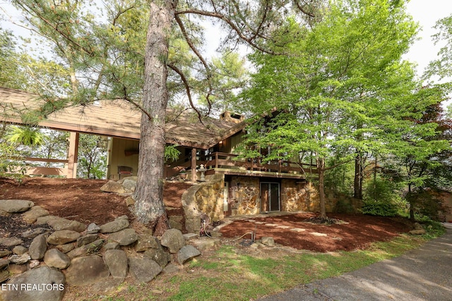 view of front of home featuring a chimney and stone siding