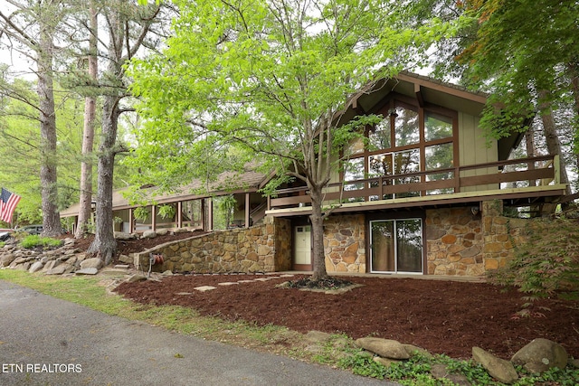 view of front of home with a wooden deck and stone siding