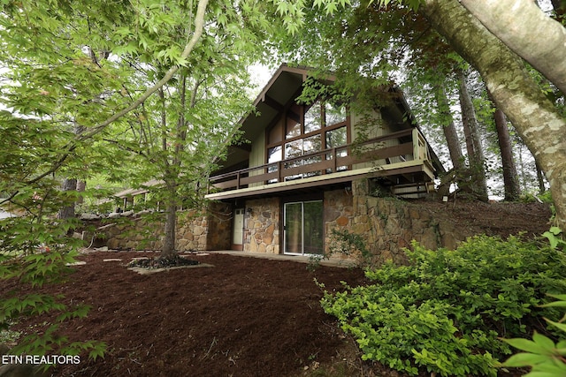 exterior space featuring stone siding and a deck