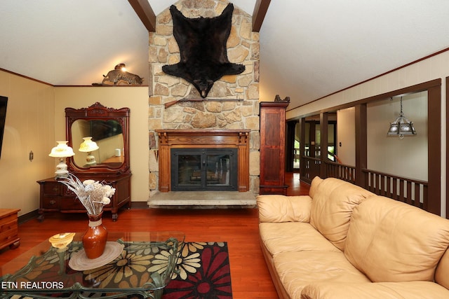 living room with a stone fireplace, ornamental molding, and wood finished floors