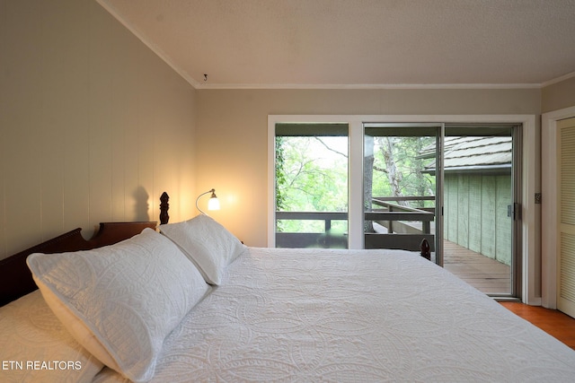 bedroom featuring ornamental molding, wood finished floors, and access to exterior
