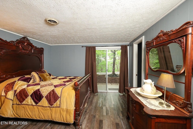 bedroom with a textured ceiling, visible vents, access to exterior, and dark wood finished floors