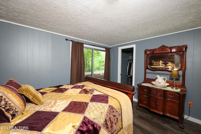 bedroom featuring baseboards, a textured ceiling, wood finished floors, and a closet