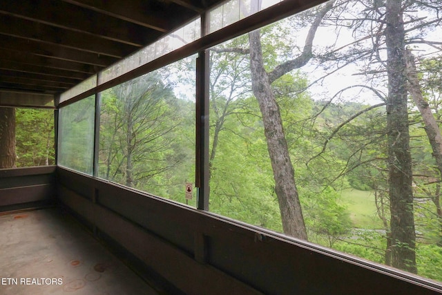 unfurnished sunroom with a forest view