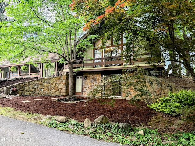 view of front facade featuring stone siding and a deck