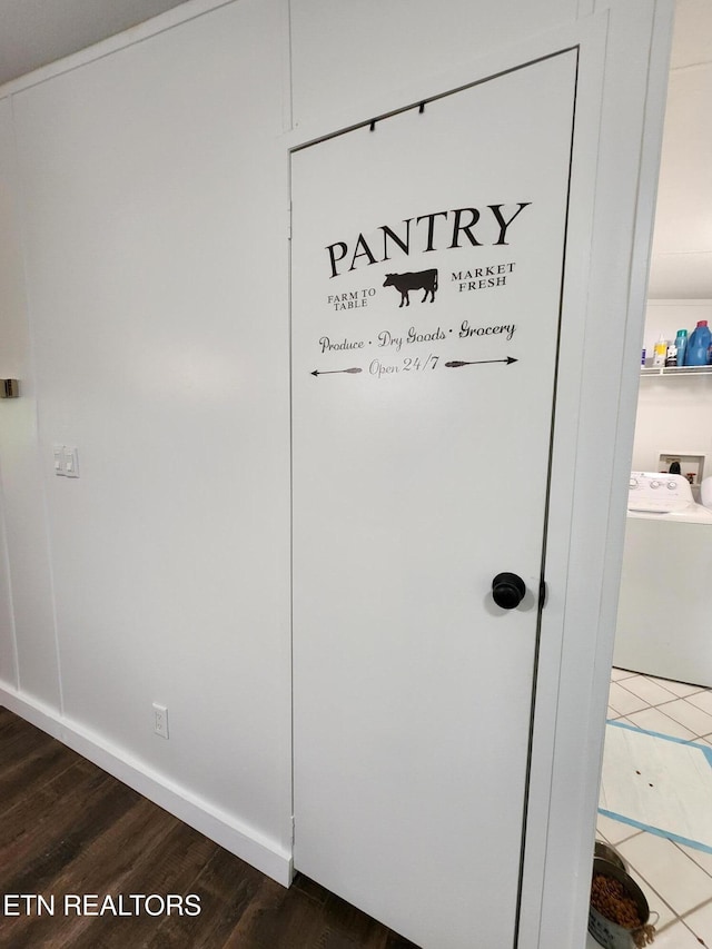 interior details with baseboards, washer / clothes dryer, and wood finished floors