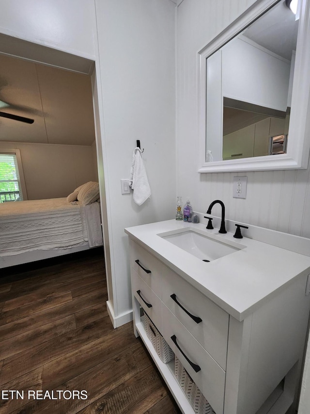 ensuite bathroom featuring vanity, ensuite bath, and wood finished floors