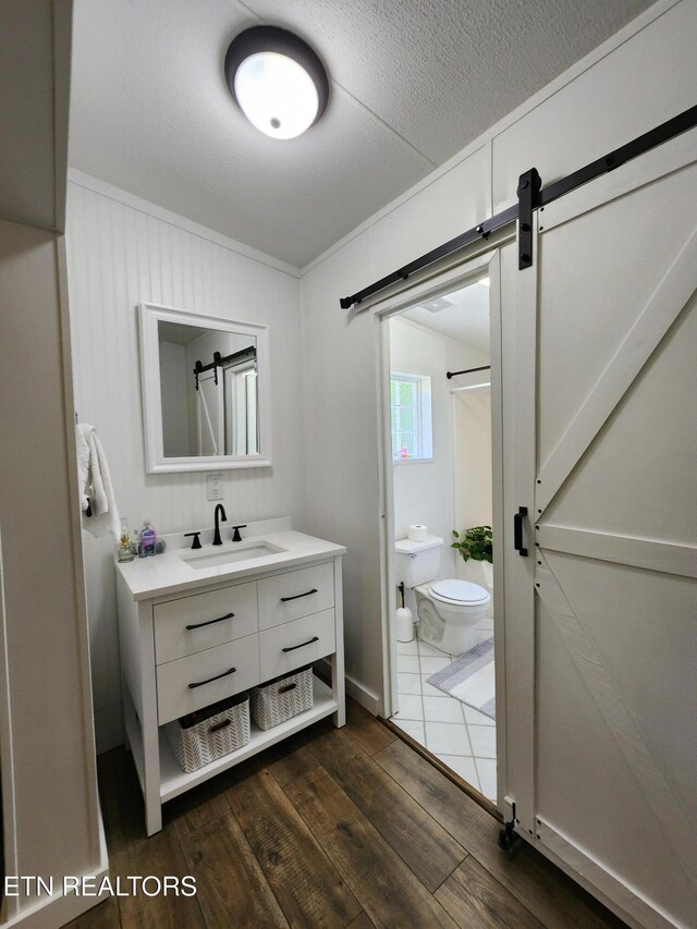 full bath with vanity, wood finished floors, toilet, and a shower