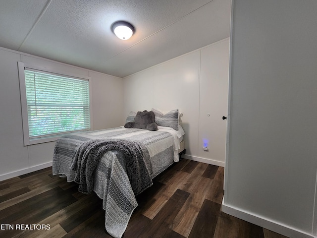 bedroom featuring baseboards, a textured ceiling, and dark wood-style floors