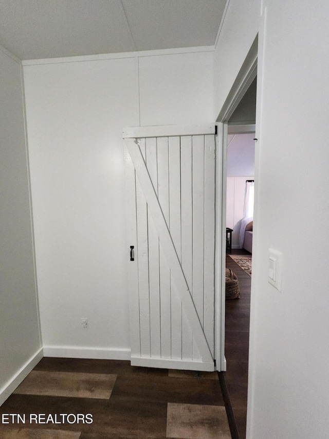hall featuring baseboards and dark wood-style flooring