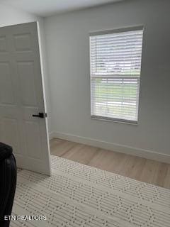 spare room with light wood-style flooring and baseboards