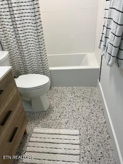 bathroom featuring shower / tub combo with curtain, vanity, toilet, and baseboards